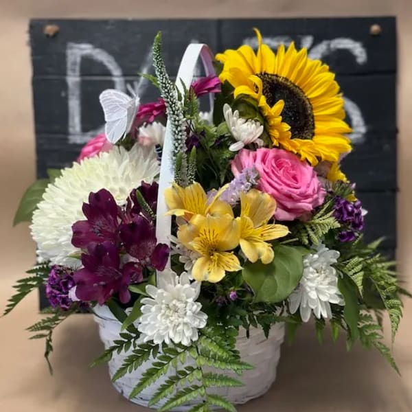 Basket arrangement with sunflowers, roses, and mixed blooms