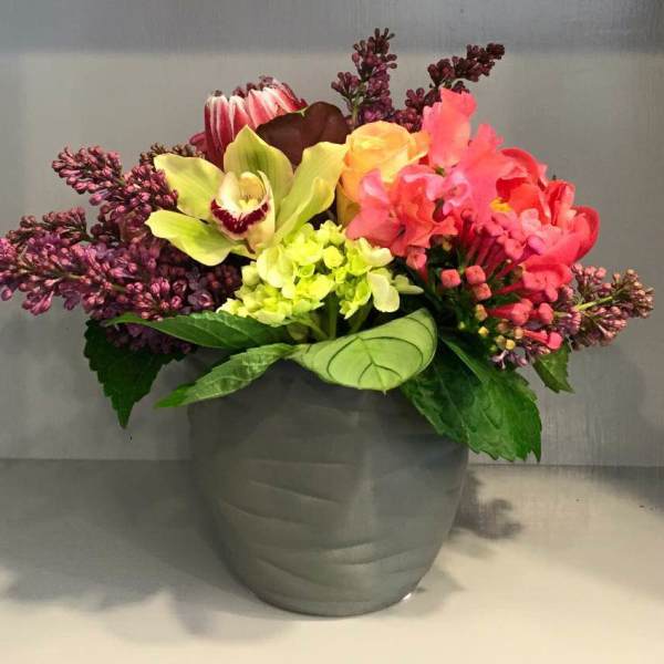 Colorful mixed flower arrangement in a gray pot