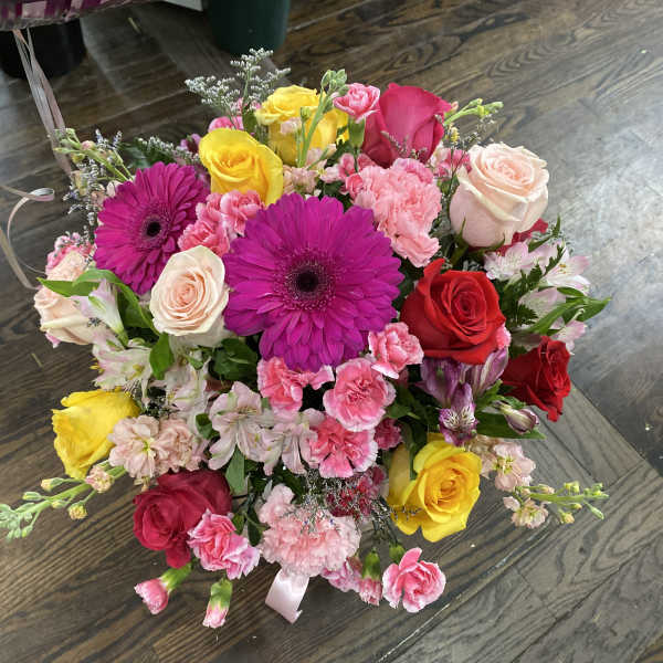 Mixed bouquet of roses, gerbera daisies, and carnations in pink, red, and yellow