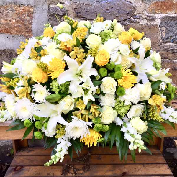 Large white and yellow floral arrangement with lilies and roses