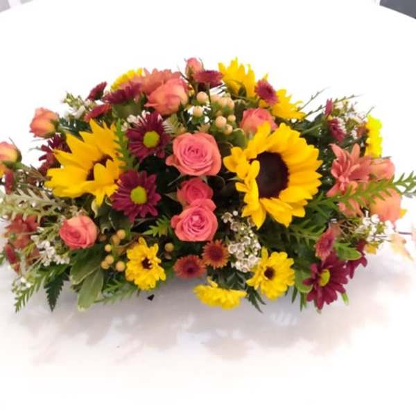 Mixed bouquet with sunflowers, pink roses, and burgundy daisies