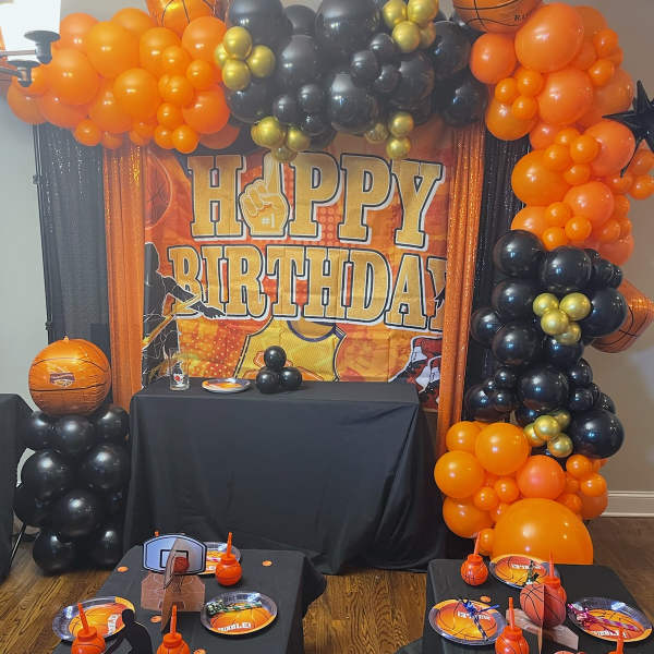 Basketball-themed birthday party setup with balloon arch and table decor