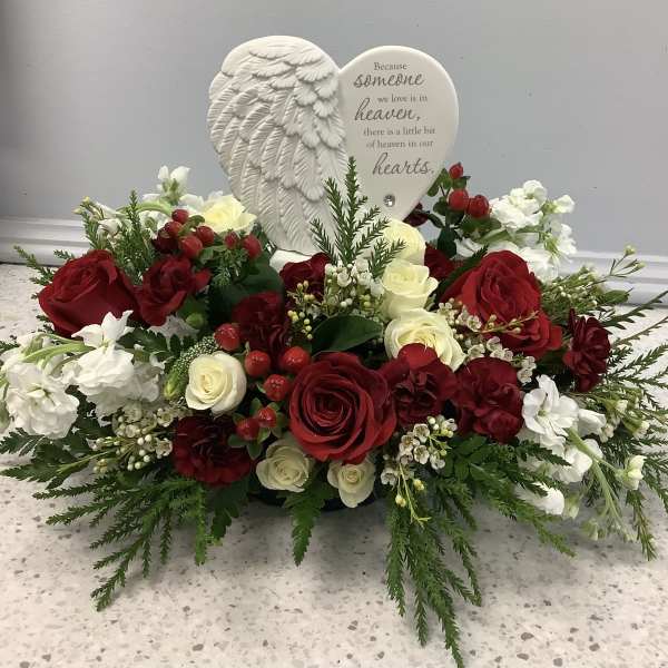 Heart-shaped sympathy arrangement with red and white roses and a memorial plaque