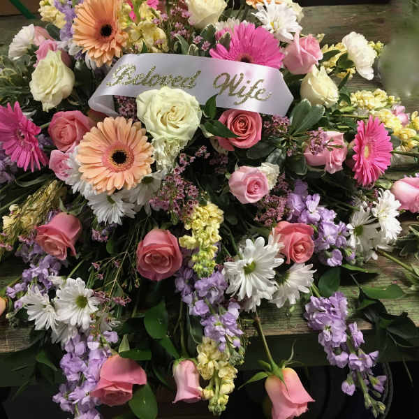 Large pink, white, and lavender floral spray with a "Beloved Wife" ribbon