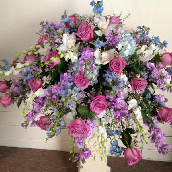 Large bouquet of pink roses, white orchids, and blue flowers