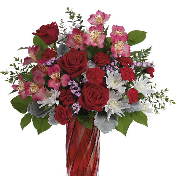 Red roses and pink alstroemeria in a red glass vase