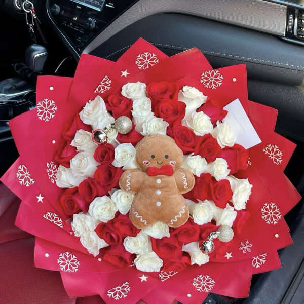 Bouquet of red and white roses with a gingerbread plush in red wrapping