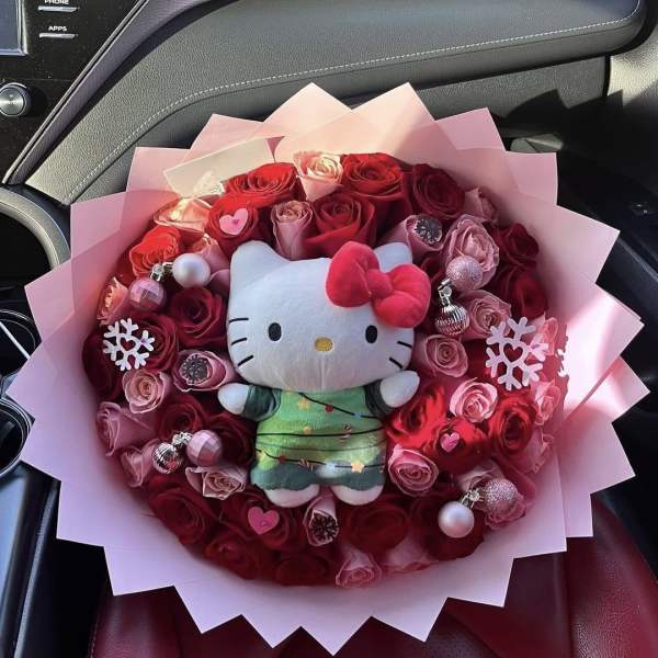 Bouquet of red and pink roses with a Hello Kitty plush in the center