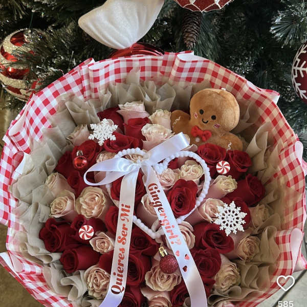 Bouquet of red and blush roses with a gingerbread plush and holiday ornaments