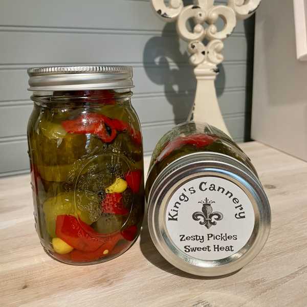 Two jars of pickles on a countertop, one upright and one lying on its side
