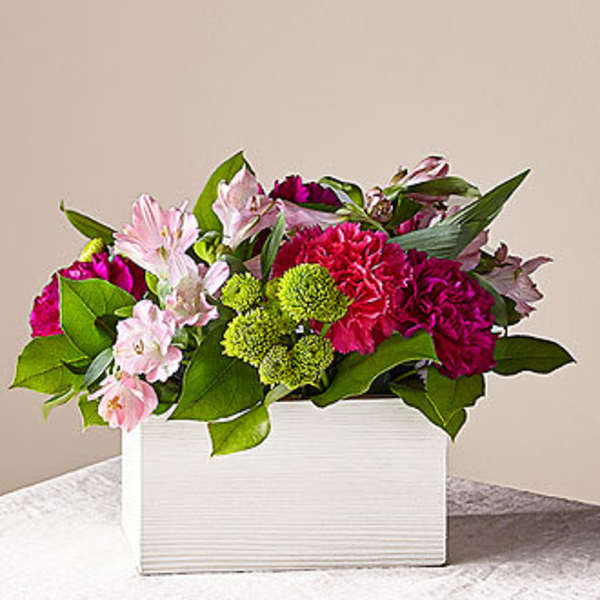Pink and magenta flowers arranged in a white rectangular box
