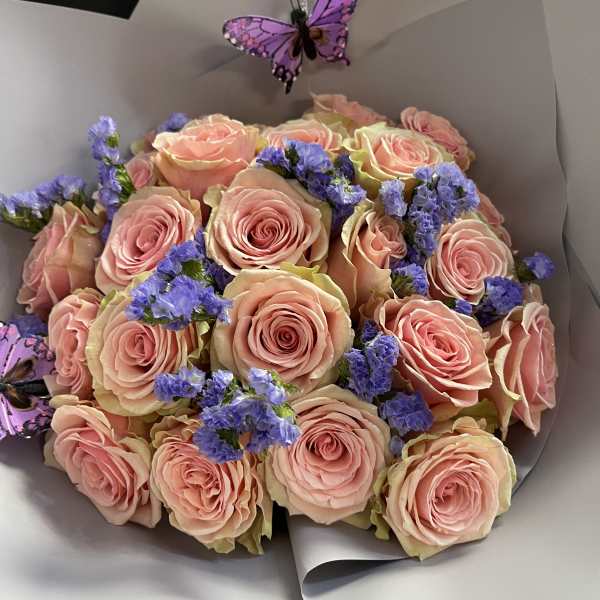 Bouquet of pink roses with purple filler flowers and butterfly decorations