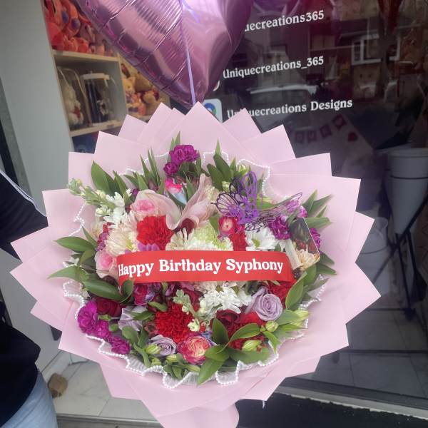 Pink bouquet with mixed flowers and a birthday ribbon