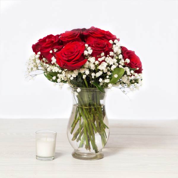 Red roses and white baby's breath in a clear glass vase