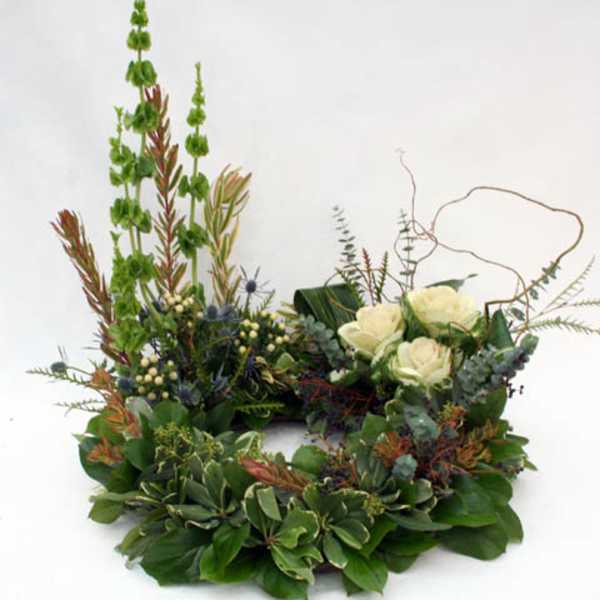 Circular floral wreath with white roses and mixed greenery