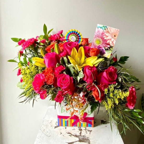 Bright mixed bouquet with roses, lilies, and carnations in a gift box