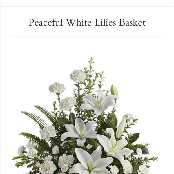 White lilies and carnations arranged in a wicker basket