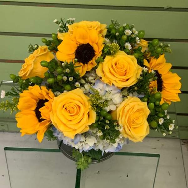 Bouquet of yellow roses and sunflowers in a vase