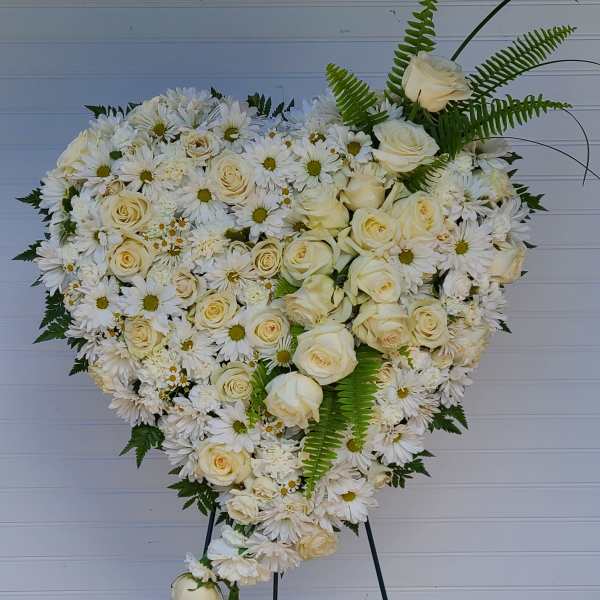 Heart-shaped white floral spray on an easel