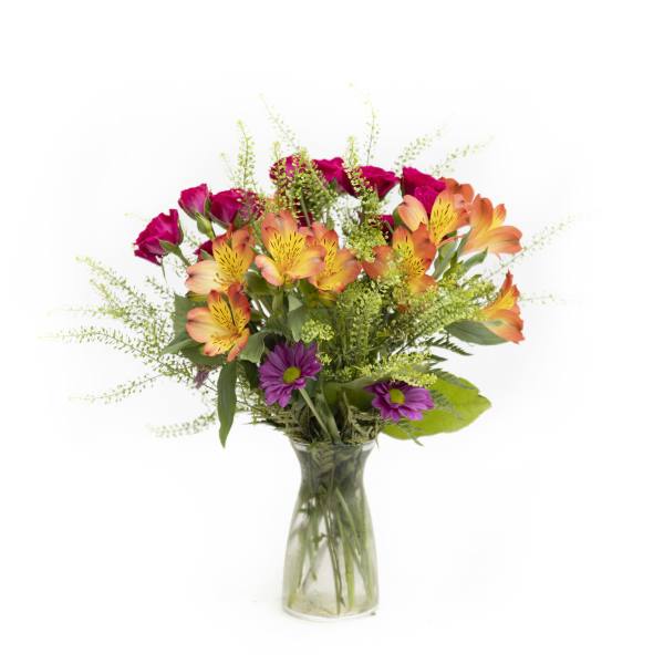 Mixed bouquet of orange alstroemeria, magenta roses, and purple daisies in a glass vase