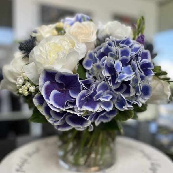 Blue and white bouquet in a clear glass vase