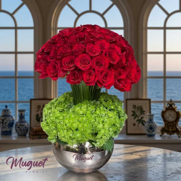Red rose arrangement with green hydrangeas in a silver bowl