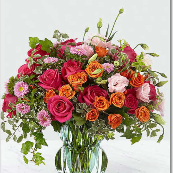 Mixed pink and orange roses in a clear glass vase