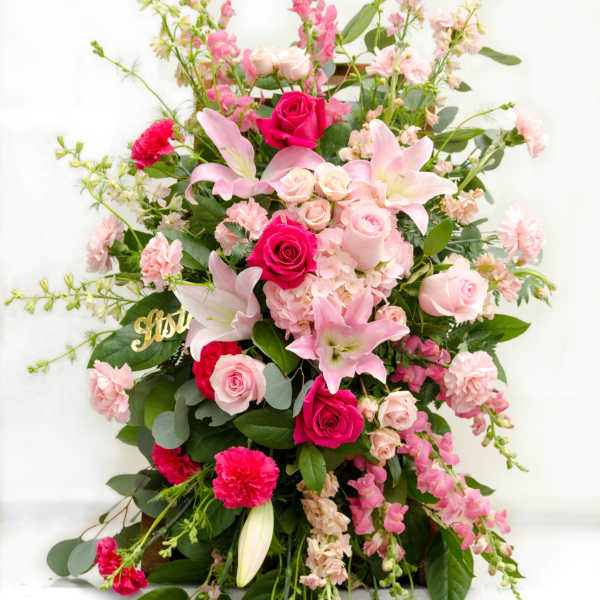 Tall pink floral arrangement with roses and lilies