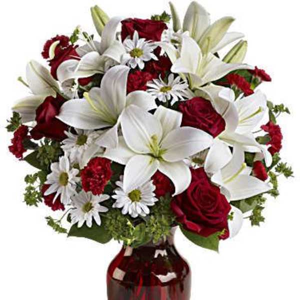 Red roses and white lilies in a red glass vase