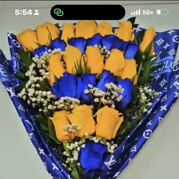 Bouquet of yellow and blue roses wrapped in patterned blue paper