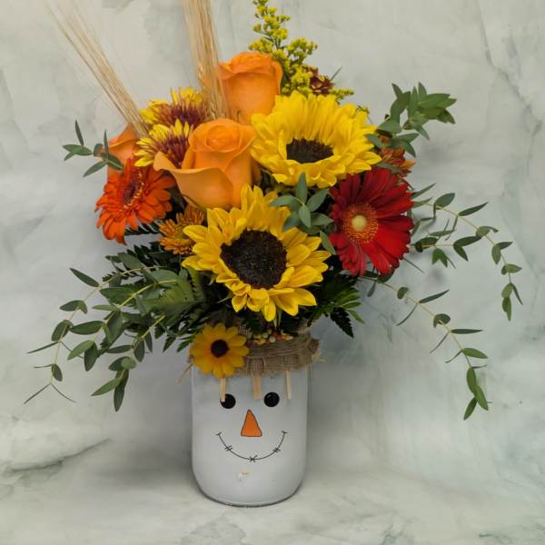 Sunflower and rose arrangement in a snowman vase