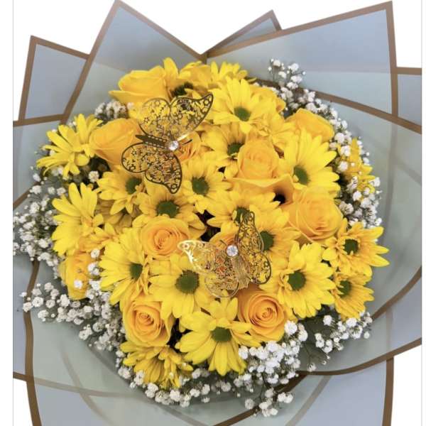 Yellow daisies and roses in a wrapped bouquet with butterfly picks