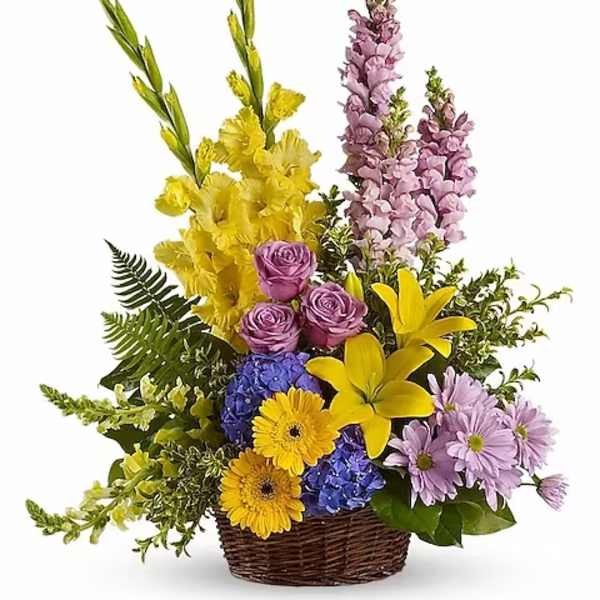 Mixed bouquet in a wicker basket with yellow, purple, and blue flowers
