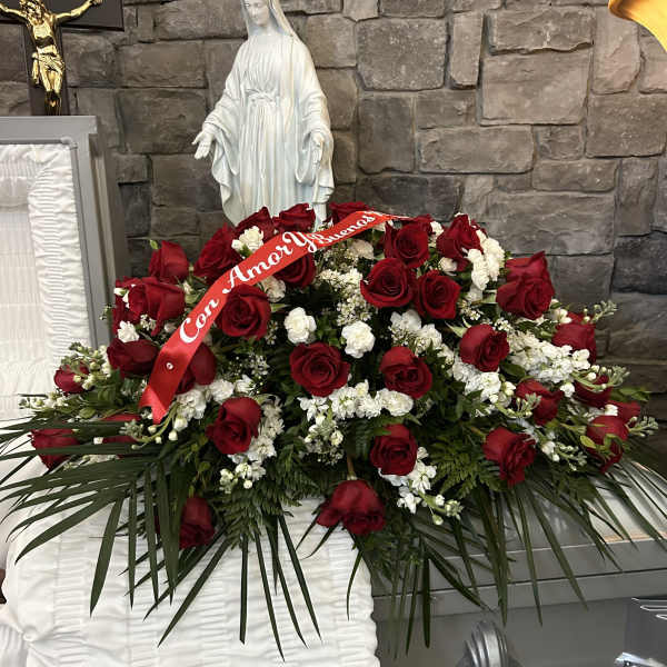 Large red rose funeral spray with white flowers and a red ribbon