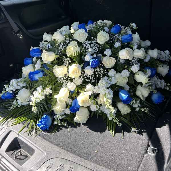Large bouquet of white and blue roses arranged in a car cargo area
