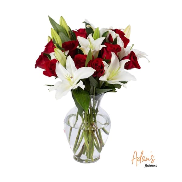 Red roses and white lilies arranged in a clear glass vase