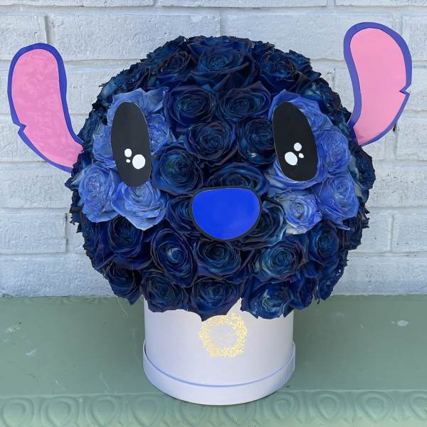 Blue rose arrangement shaped like a cartoon bear face in a white box