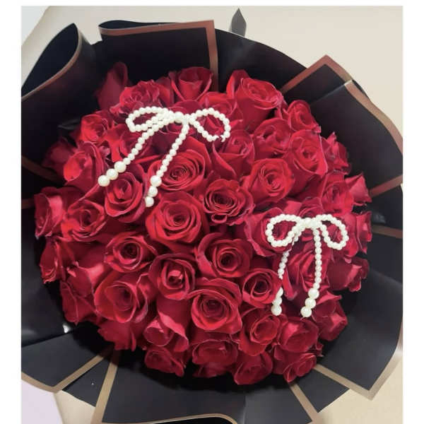 Bouquet of red roses wrapped in black paper with pearl bow accents