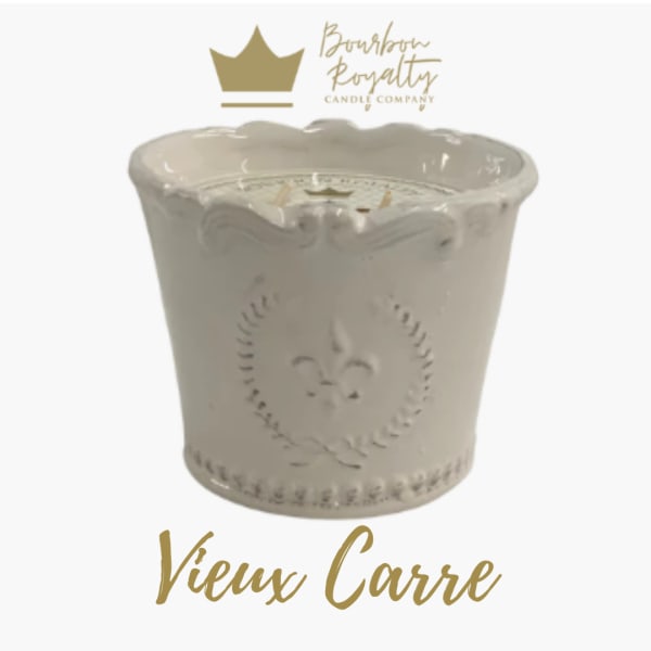 White decorative candle in a scalloped ceramic container