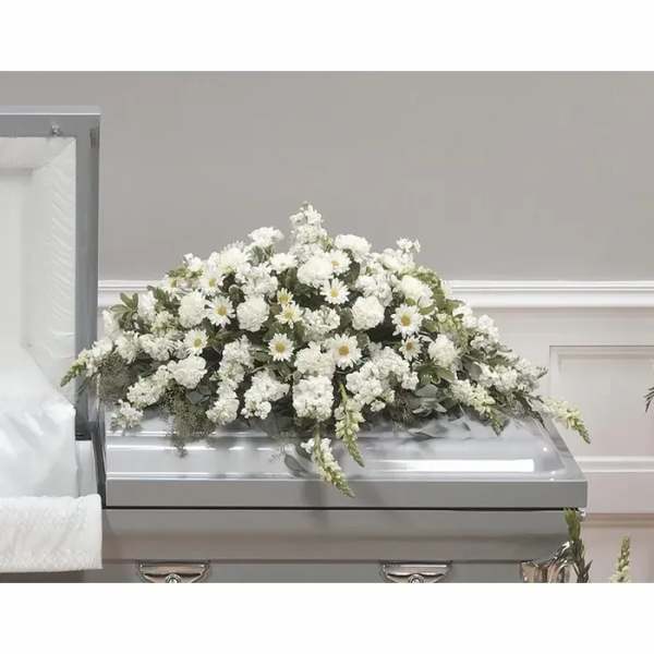 White floral casket spray with daisies and carnations