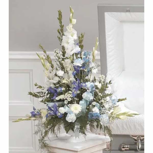 Tall white, blue, and purple floral arrangement in a white vase