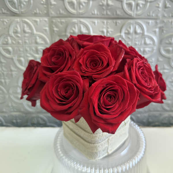 Red roses arranged in a white hatbox