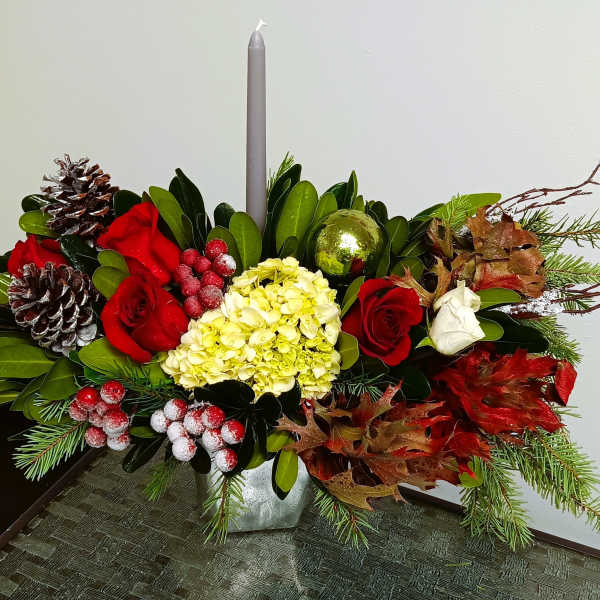 Holiday centerpiece with red and white roses, hydrangea, and a gray candle