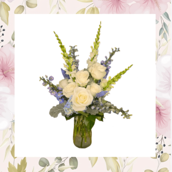 White roses and blue flowers arranged in a glass vase