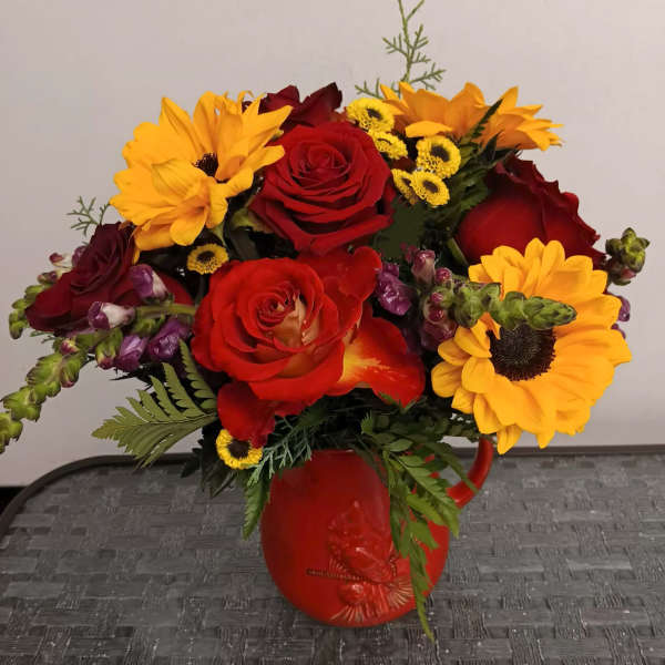Bouquet of red roses and yellow sunflowers in a red vase