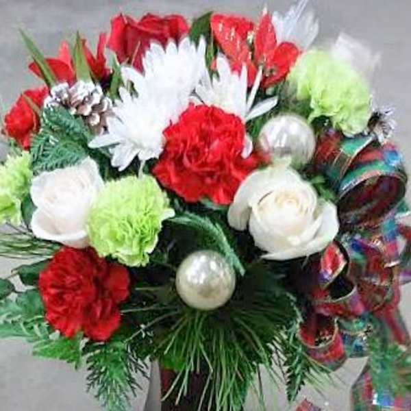 Red and white floral arrangement with ornaments and ribbon in a vase