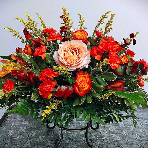 Large arrangement of red and orange roses with a pale peach rose center