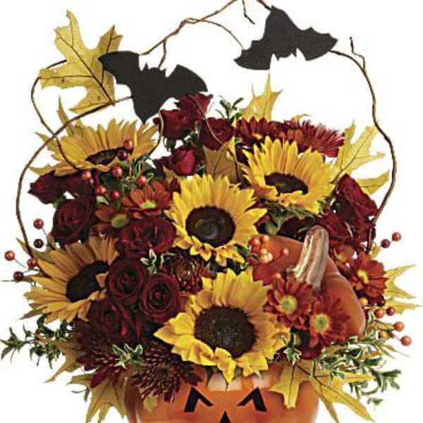 Halloween bouquet in a jack-o'-lantern container with sunflowers and roses