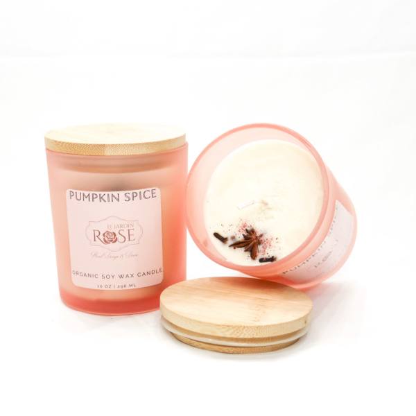 Two pumpkin spice candles in pink glass jars with bamboo lids