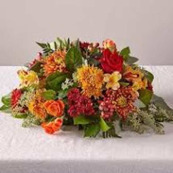 Mixed bouquet of orange, red, and yellow flowers on a white cloth